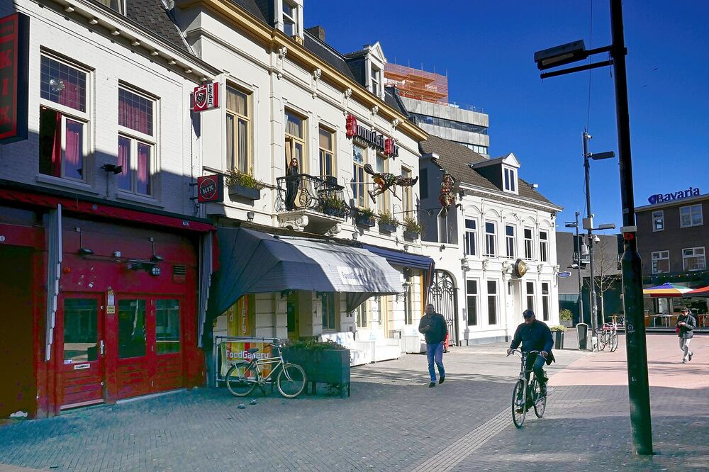 Cafés en bars aan het Stratumseind in Eindhoven, met een fietser op straat